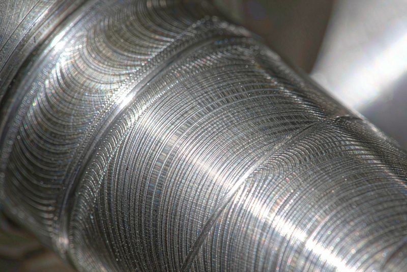 Close-up of a turned stainless steel shaft journal showing helical feed marks