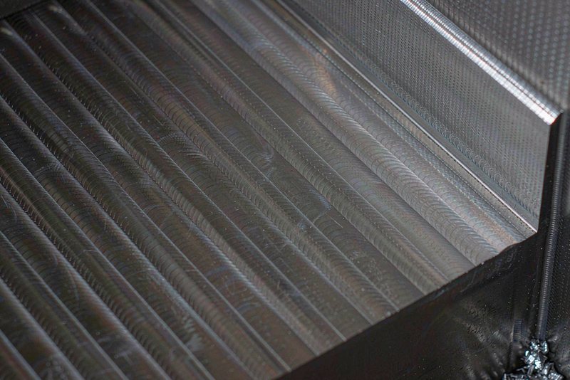 Machined aluminum pocket floor with parallel face mill marks and visible scallops