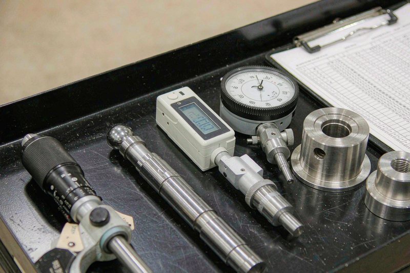 Inspection instruments and a printed measurement sheet laid out with machined parts