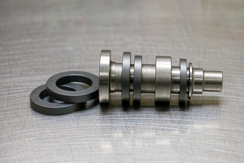 Stepped shaft with machined spacer rings arranged in assembly order on a bench