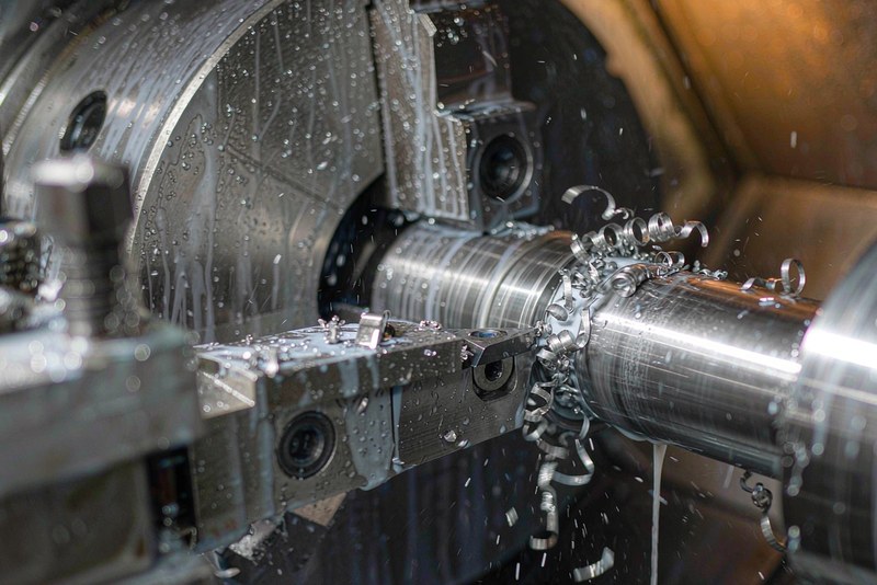 Stainless steel shaft being turned in a CNC lathe with short chips breaking off