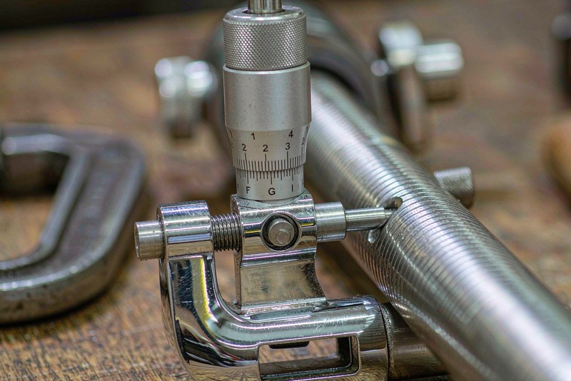 Outside micrometer measuring the turned diameter of a stainless steel shaft