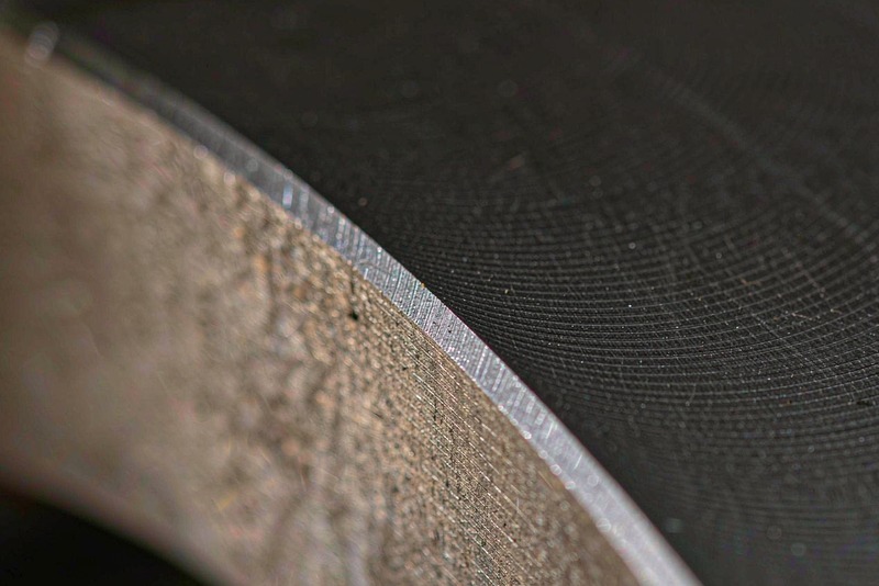 Close-up of a machined steel surface showing fine turning marks under a matte black finish
