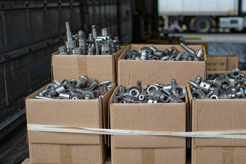 Pallet loaded with cartons of machined metal parts in a shipping bay
