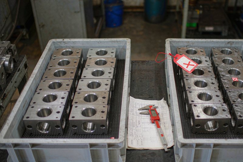 Two trays of machined housings after sorting, one lot tagged on hold