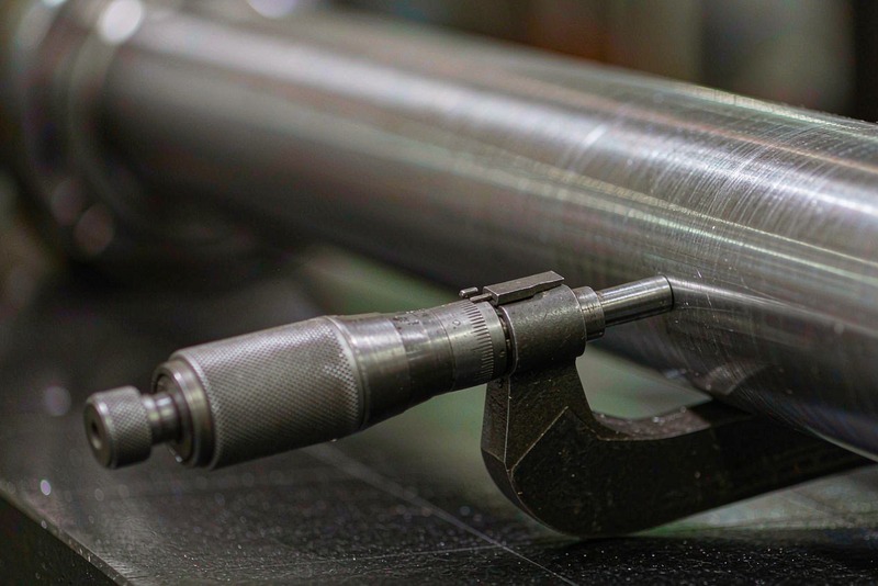 Outside micrometer seated on a turned steel shaft resting on a granite plate