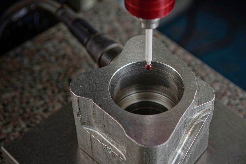 CMM probe contacting the wall of a machined aluminum housing bore