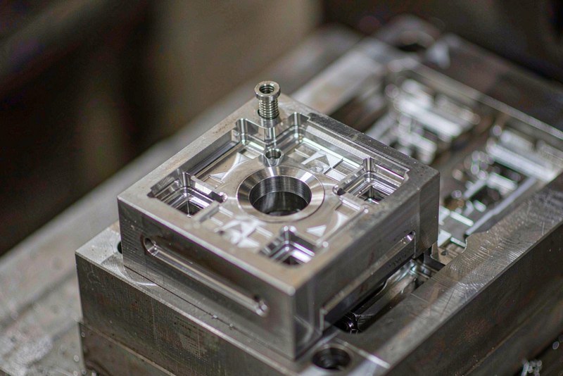 Polished steel mold cavity insert with machined pockets and ejector holes