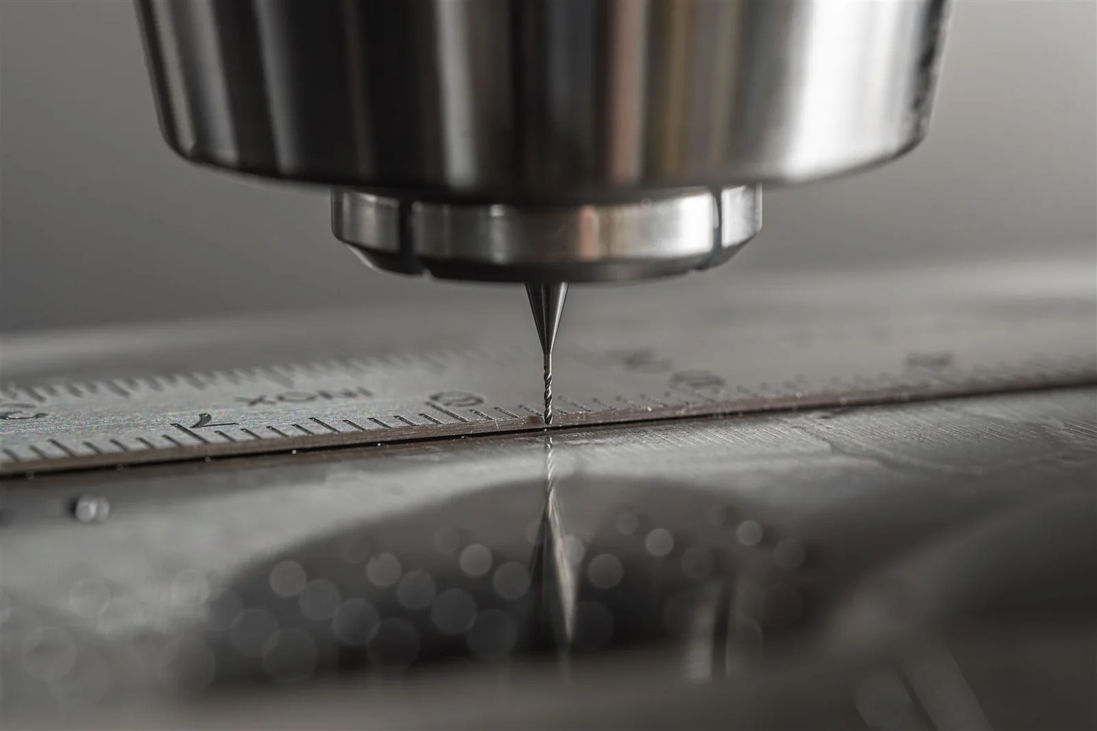 Close-up of a small machining tool beside a machined feature