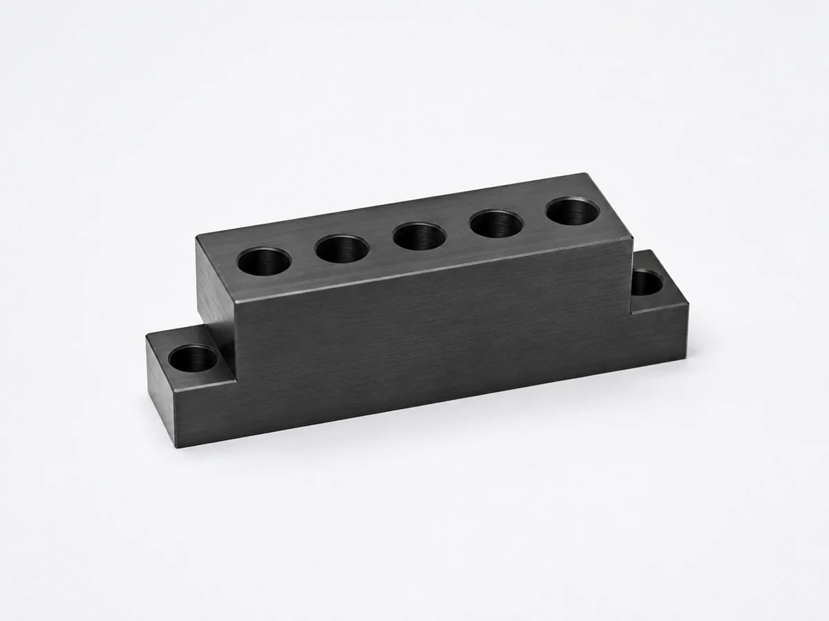 Illustrative steel mounting block with a dark black oxide appearance