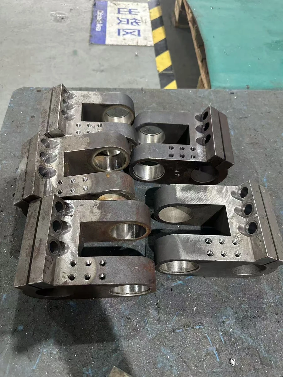 User-provided photograph of HongKe machined clevis brackets with bores, slots and fixing holes